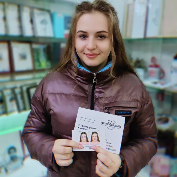 Девушка держит в руках фотографии на документы