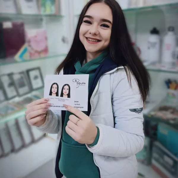 Девушка держит в руках фотографии на документы