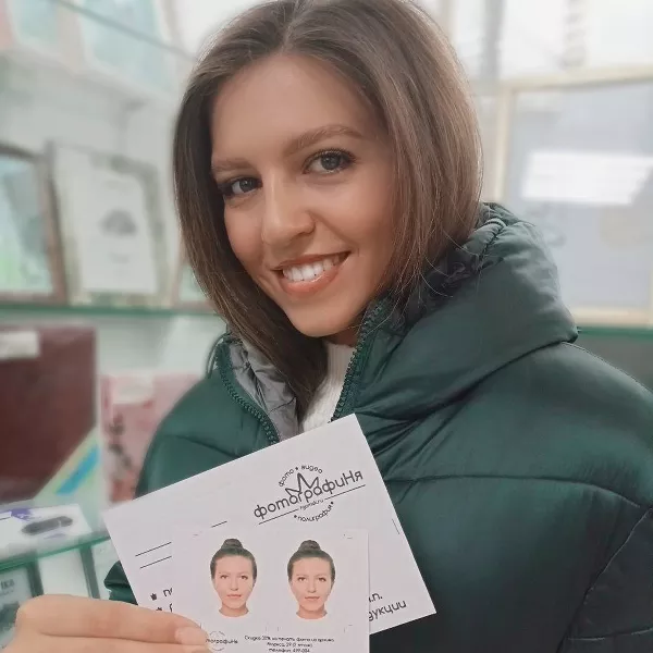 Девушка держит в руках фотографии на документы