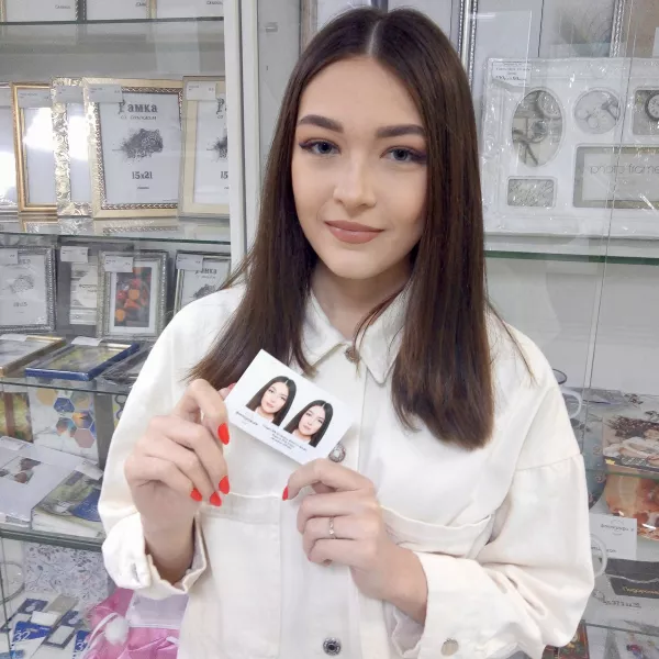 Девушка держит в руках фотографии на документы