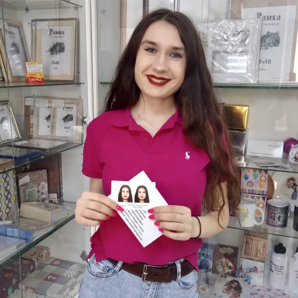 Девушка держит в руках фотографии на документы