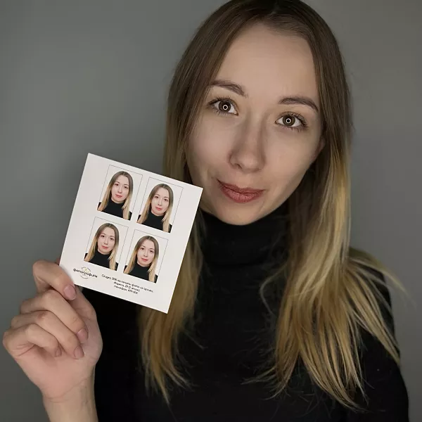 Девушка держит в руке фотографии на документы